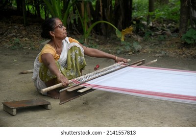 Morigaon, India. 31 March 2022. Assamese woman weaves Assamese Traditional Gamosa in handloom, ahead of Rongali Bihu festival on March 31, 2022 in Mayong, Morigaon,  India.