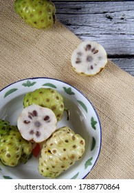 Morinda citrifolia or noni fruit is also known as mengkudu in Indonesia. Popular to used as traditional medicine. Has strong smell and bitter taste. Served on enamel plate.