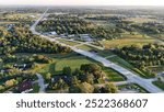 Morning aerial view of State Highway 646 in Santa Fe, Texas, captured from 184 feet. The road stretches towards Dickinson, surrounded by greenery under a peaceful sky.