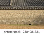 Morning and autumnal view of grass and stonewall of tile-roofed house at Jongmyo Shrine, Seoul, South Korea
