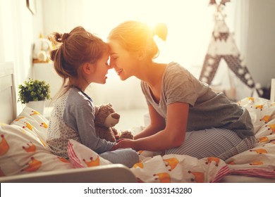 despertar por la mañana. madre despierta a su hija en la cama por la mañana
 Foto de stock