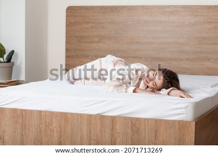 Morning of beautiful young woman lying on bed with soft mattress