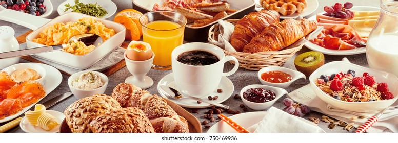 Morning breakfast banner with a coffee cup served surrounded by various nutritious food as delicious French croissants, cereals, and fruits - Powered by Shutterstock