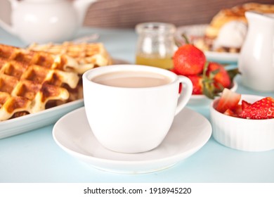 Morning breakfast. Cup of tea with freshly homemade baked waffles with strawberries and honey - Shutterstock ID 1918945220