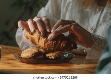 Morning breakfast. Woman eating croissant in coffee shop. - Powered by Shutterstock