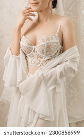 Morning of the bride in a beautiful white corset bra and dressing gown, wedding