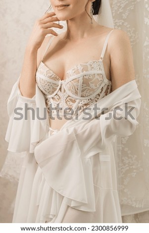 Morning of the bride in a beautiful white corset bra and dressing gown, wedding
