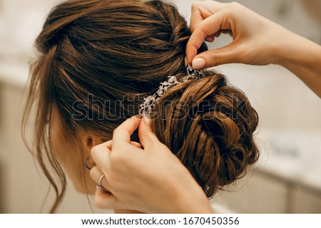 The morning of the bride. Girl makes a stylish hairstyle, a friend helps the bride, a beautiful hair ornament, preparation for a party, close-up hairstyle