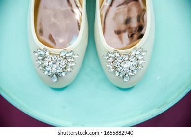 The Morning Of The Bride. Wedding Ballet Flats Shoes Of The Bride On A Blue Round Table