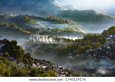 A morning city sunray valley landscape view of Aizawl city with clouds and rays in India