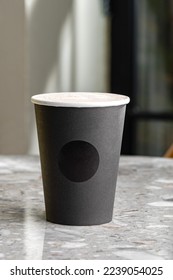 Morning coffee in black paper cup, take-away mug under light and shadown through tree. Aroma drink wakes body. mockup
