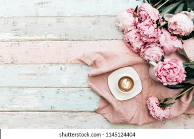Morning coffee cup concept. Pink peony bouquet on vintage background. Top view, copy space 