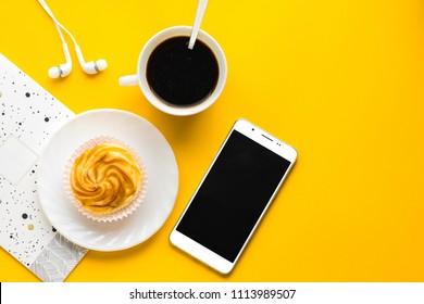 Morning Coffee, Delicious Cake On White Plate, Mobile. Copy Space. Top View. Yellow Background. Birthday In Office Background