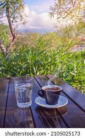 Morning Coffee. Glass Of Water And  Cup Of Coffee On Table In Garden