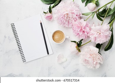 Morning coffee mug for breakfast, empty notebook, pencil and pink peony flowers on white stone table top view in flat lay style. Woman working desk. - Powered by Shutterstock