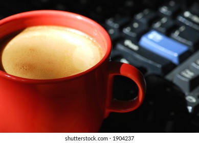 Morning coffee near computer keyboard