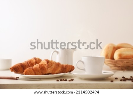 Morning coffee on a white wooden table with plate with two croissants and bread with isolated white background. Front view. Horizontal composition.