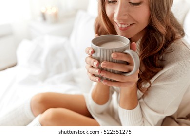 Morning, Coziness, Winter And People Concept - Close Up Of Happy Young Woman With Cup Of Coffee Or Cacao In Bed At Home