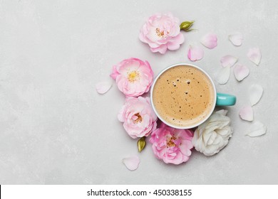 Morning Cup Of Coffee And A Beautiful Roses Flowers On Light Background, Top View. Cozy Breakfast. Flat Lay Style.