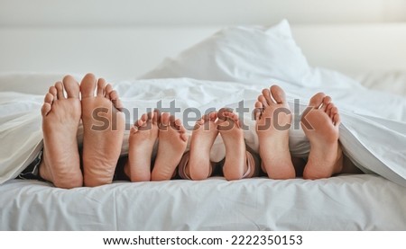 Morning, feet and family sleeping in bedroom for weekend, holiday or nap leisure in house. Relax, mother and dad with young children resting in bed with blanket in family home together.