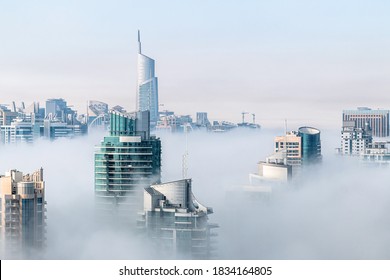 Morning fog hovering skyscrapers at sunrise. Aerial view of building rooftops over the clouds in Dubai Marina
 - Powered by Shutterstock