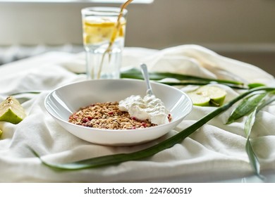 Morning granola breakfast with greek yougurt and glass of detox water with lemon, Homemade oatmeal granola, healthy food. - Shutterstock ID 2247600519