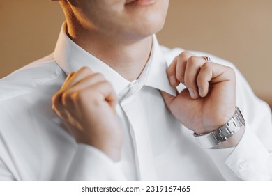 Morning of the groom and details, white shirt, good light, young man, stylish groom getting dressed, getting ready for the wedding ceremony. close-up of male hands, - Powered by Shutterstock