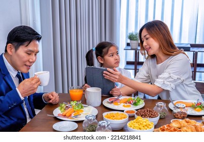 In The Morning At Home The Family Husband Eating And Children Girl Play Game Do Not Want To Eat Happy Smile Talking To Each Other And Laughing Before Breakfast And Go To Work And School