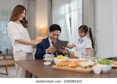 In The Morning At Home The Family Husband Hold Tablet Read News Wife And Children Girl Happy Smile Talking To Each Other And Laughting Before Breakfast And Go To Work And School
