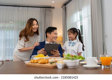 In The Morning At Home The Family Husband Hold Tablet Read News Wife And Children Girl Happy Smile Talking To Each Other And Laughting Before Breakfast And Go To Work And School
