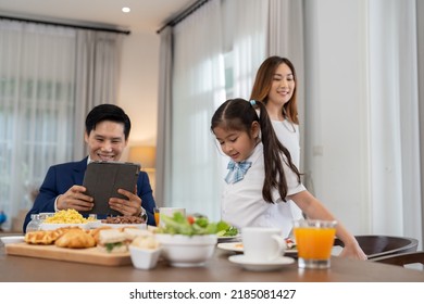 In The Morning At Home The Family Husband Hold Tablet Read News Wife And Children Girl Happy Smile Talking To Each Other And Laughting Before Breakfast And Go To Work And School
