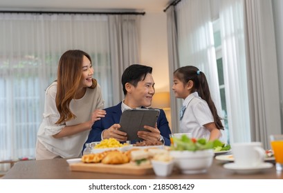 In The Morning At Home The Family Husband Hold Tablet Read News Wife And Children Girl Happy Smile Talking To Each Other And Laughting Before Breakfast And Go To Work And School
