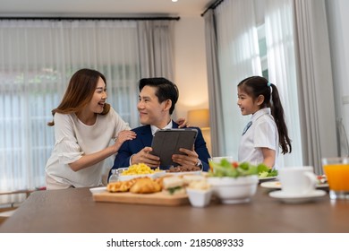 In The Morning At Home The Family Husband Hold Tablet Read News Wife And Children Girl Happy Smile Talking To Each Other And Laughting Before Breakfast And Go To Work And School
