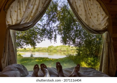 Morning in a house on the banks of the river. Large window by the bed. Beach