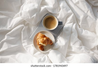 Morning, Hygge And Breakfast Concept - Croissants, Cup Of Coffee And Book In Bed At Home