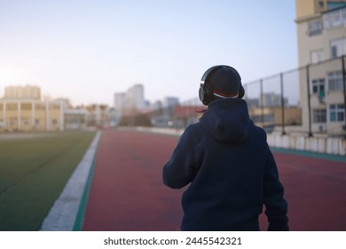 Morning Jog with Headphones on City Track - Powered by Shutterstock