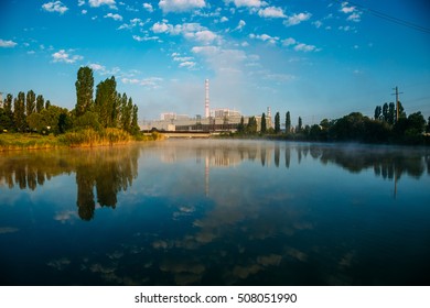 Morning At The Kurchatov Water Reservoir. Kursk Nuclear Power Plant Reflecting In Calm Water