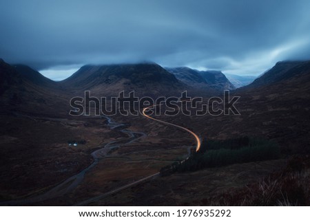 Morning landscape with car lights on the mountain road leading to Glencoe opposite Buachaille Etive Mor. A82 road before dawn. Scotland Stock photo © 