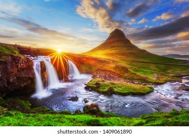 Morning landscape with rising sun on Kirkjufellsfoss waterfall and Kirkjufell mountain, Iceland, Europe.