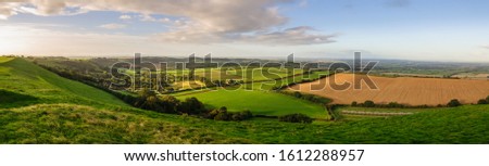 Morning light illuminates the landscape of the Somerset Levels viewed from Corton Beacon hill in South Somerset, England.