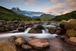 Morning Light Paints The Peaks Of The Drakensberg Mountains, With The Tugela River Flowing Gently Below