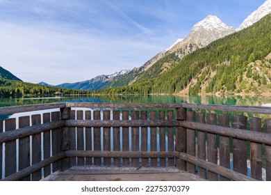 Morning light and still water with reflections at Lake Anterselva, also known as AntholzerSee or Lake Antholz, in South Tyrol, Italy.