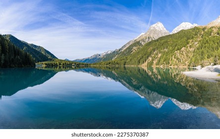 Morning light and still water with reflections at Lake Anterselva, also known as AntholzerSee or Lake Antholz, in South Tyrol, Italy.