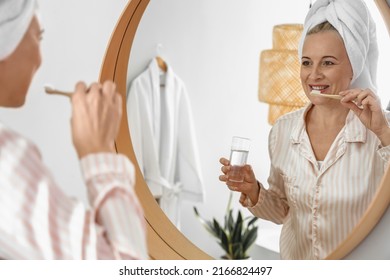 Morning Of Mature Woman Brushing Teeth In Bathroom