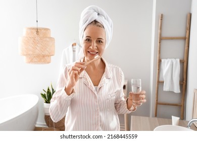 Morning Of Mature Woman Brushing Teeth In Bathroom