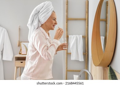 Morning Of Mature Woman Brushing Teeth In Bathroom