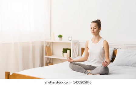 Morning Meditation. Woman Practising Yoga In The Morning, Sitting On Bed, Free Space