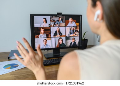 Morning meeting online. A young woman is using app on pc for connection with colleagues, employees. Video call with many people together. Back view - Shutterstock ID 1721381962