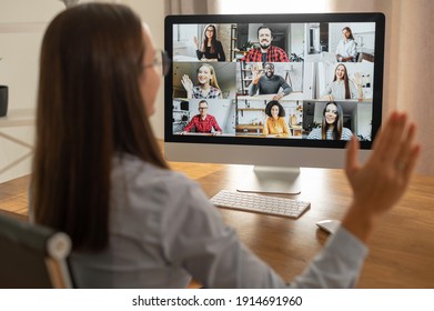 Morning Meeting Online. A Young Woman Is Using App On Pc For Connection With Colleagues, Employees. Video Call With Many People Together. Back View