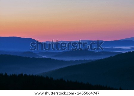Morning in the mountains. Landscape with fog in the valley between the mountains in the early morning